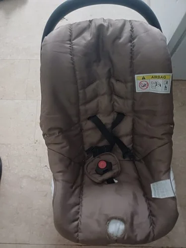 Beige newborn car seat with airbag warning